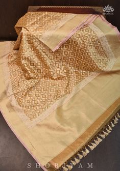 This Saree is an ode to the rich design traditions of Banaras. It is set in an elegant and earthly beige hue. The fine body of the saree features delicately woven motifs in atrellis jaal . This is complimented perfectly by the grand pallu. The base material used to craft the saree is kora or pure silk organza and tissue. In addition to this, we have incorporated designer tassels on the sarees to elevate its charm.   SILK MARK CERTIFIED This saree is ready to wear with fall and pico done. Handmade silk tassels adorn the pallu and add more grace to it. An unstitched blouse fabric is included. *Note: There may be minor variations in the shade, the texture of the product. Hues/textures show differently due to variations in screen settings and other factors, *Note: This is a handwoven saree and Gold Pre-draped Dola Silk Saree With Dupatta, Gold Pre-draped Saree With Traditional Patterns For Festivals, Festive Banarasi Silk Pre-draped Saree With Self Design, Semi-stitched Gold Pre-draped Saree With Dupatta, Festive Beige Blouse Piece With Traditional Drape, Beige Semi-stitched Saree, Handloom Pre-draped Saree For Eid, Gold Pre-draped Saree With Cutdana For Navratri, Traditional Gold Pre-draped Saree For Navratri