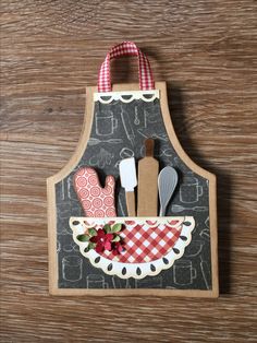 an oven mitt with utensils and spoons in it on a wooden surface