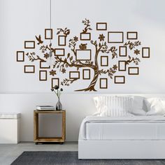 a bedroom with a tree wall decal in the shape of frames and birds on it