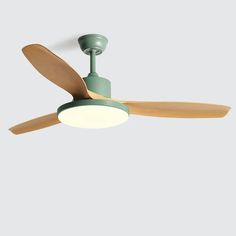 a green ceiling fan with wooden blades and a light on the top, against a gray background