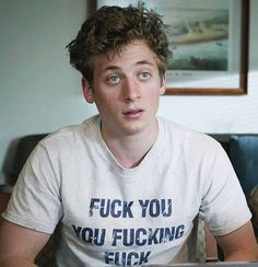 a young man sitting in front of a laptop computer