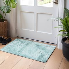 a pair of black slippers sitting on top of a wooden floor next to a door