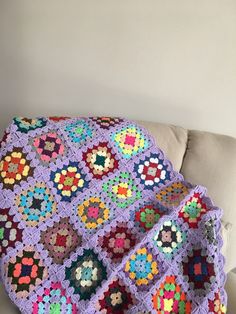 a crocheted granny blanket sitting on top of a couch