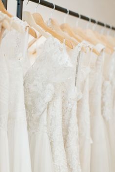 wedding dresses hanging on racks in a bridal shop