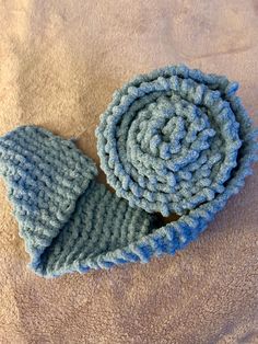 a pair of blue knitted mittens laying on top of a bed