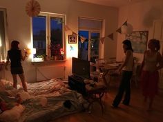 three women standing in a room with a bed