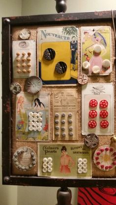 an old framed display with buttons and other items on it's side, hanging from the wall