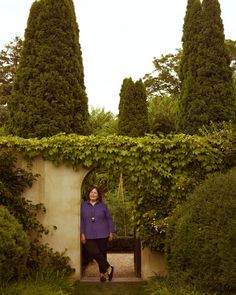 a woman standing at the entrance to a garden