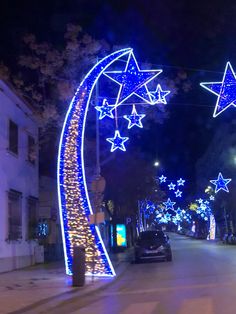 a car driving down a street with blue lights on the sides and stars hanging from the ceiling