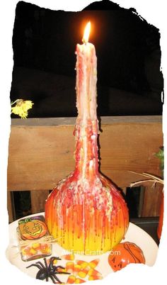 a lit candle sitting on top of a table next to candies and pumpkins