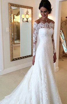 a woman in a white wedding dress posing for the camera with her hand on her hip