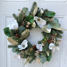 a wreath with white flowers and green leaves