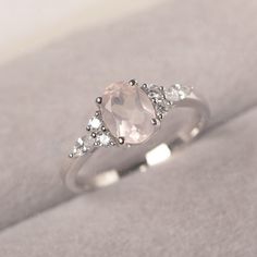 * The delicate ring displays pink quartz as main stone. The cluster side stones make the ring similar to the blooming flower . For who wearing this special & delicate ring, will shine like a goddess. ◆ Production Description: Main stone Type: Pink Quartz Main Stone Shape: Oval Cut Main Stone Size: 6*8mm (1.14ct) Side stone: CZ Metal: 925 Sterling silver - Other options available in the drop down menu ◆ Customization: √Free for Add Engraving √Other Metal Type Available √Other Gemstones & Rose Quartz Engagement Ring Silver, Feminine Pink Wedding Rings, Promise Ring With Rose Quartz And Gemstone Detail, Pink Crystal Ring For Wedding, Fine Jewelry, Rose Quartz Crystal Ring For Promise, Fine Jewelry Pink Crystal Wedding Ring, Pink Fine Jewelry Crystal Ring For Wedding, Pink Moonstone Promise Ring, Pink Crystal Ring With Center Stone For Wedding