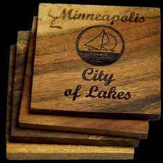 three wooden coasters with the words minneapolis city of lakes engraved on them, sitting next to each other