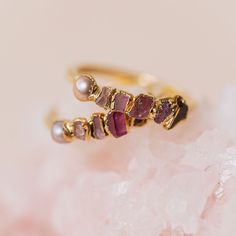 "PINK OMBRE BIRTHSTONE RING Love all things pink? This pink ombre ring has your name on it. Featuring raw garnet, ruby, pink tourmaline, morganite, and pink pearl stones, this ring has birthstones for January, July, October, and June. * Features garnet, ruby, pink tourmaline, morganite, and pink pearl * Contains January, July, October, and June birthstones ♦ THE LITTLE DETAILS * One ombre ring * Hand formed rings do fit snug, size up if between sizes! * Hand-hammered ring band * Ring band width: Ruby Birthstone Ring, Pink Pearl Jewelry, Pink Pearl Ring, Ombre Rings, Raw Pink Tourmaline, Pink Stone Ring, Raw Garnet, Pink Morganite Ring, Gemstone Stacking Ring