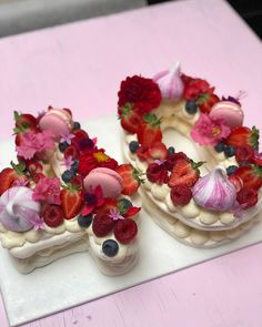 there is a cake decorated with fruit and flowers on the table next to each other