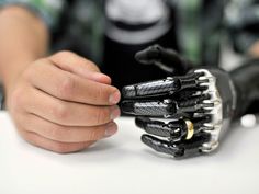 a person holding a robotic hand on top of a table