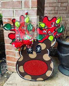 a cardboard reindeer head sitting next to a brick wall