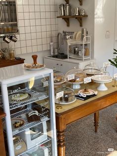 a kitchen filled with lots of food on top of a wooden table