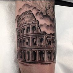 a man's arm with a black and grey tattoo of the colossion