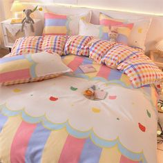 a bed with colorful comforters and pillows on it