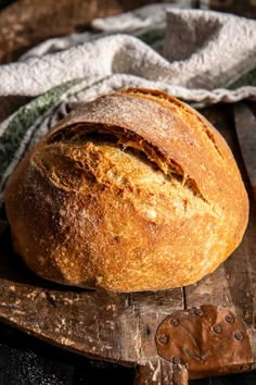 a loaf of bread sitting on top of a wooden cutting board