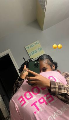 a woman taking a selfie while wearing a pink shirt with the word hope on it