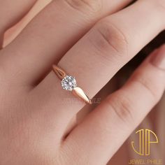 a woman's hand with a diamond ring on top of her finger, showing the side view