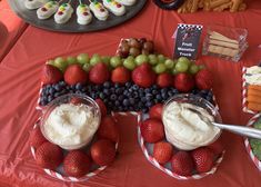 a table topped with plates filled with fruit and veggies next to desserts