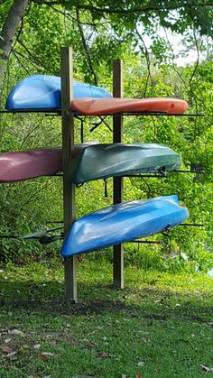 there are many surfboards on the rack in the woods