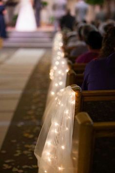 people are sitting in pews with lights on them