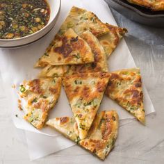 several pieces of flat bread on a napkin next to a bowl of soup