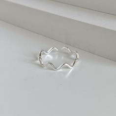 "Immerse yourself in the elegance of the sea with the Minimalist Dainty Sterling Silver Wave Ring. Delicately crafted from 925 Sterling Silver, this unique ring captures the essence of the timeless dance of the ocean waves in the form of a wave ring. Each wave is intricately designed, flowing seamlessly into the next, creating a harmonious circle that encases your finger with grace. This statement ring is more than just an accessory; it's a wearable piece of art. Its dainty ring design, reminisc Silver Wave Ring, Minimalist Wavy Rings As A Gift, Minimalist Wavy Rings For Gift, Minimalist Wavy Rings As Gifts, Minimalist Sterling Silver Wavy Ring, Simple Silver Ring, Best Friend Rings, Friend Rings, Silver Rings Simple