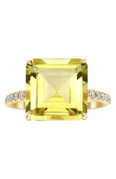 a yellow diamond ring with diamonds on the sides and an emerald stone in the middle