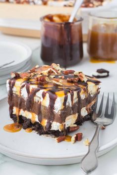 a piece of cake on a plate with a fork and some dessert in the background