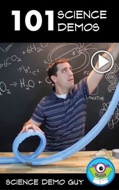 a man holding a blue tube in front of a blackboard