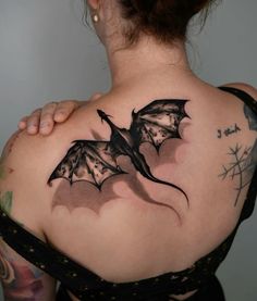 a woman with a bat tattoo on her back