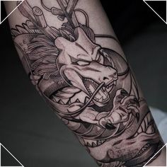 a man's arm with a dragon and scissors tattoo design on the left forearm