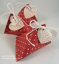 three pieces of red paper with white polka dots and hearts on them, tied together