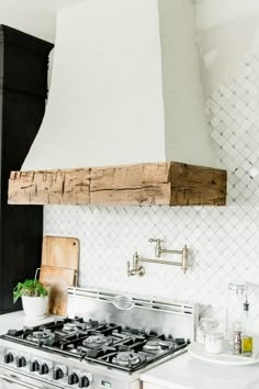 a stove top oven sitting inside of a kitchen next to a wall mounted range hood