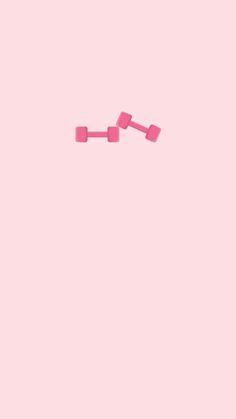 two pieces of pink legos against a light pink background, with one piece falling off the ground