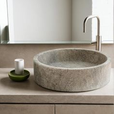 a bathroom sink sitting on top of a counter next to a cup and saucer