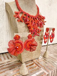 an orange beaded necklace and matching earrings on display