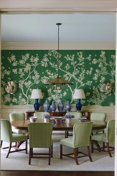 the dining room is decorated in green and white with blue vases on the table