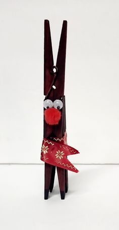 a wooden reindeer with glasses and a red ribbon tied around its neck on a white background