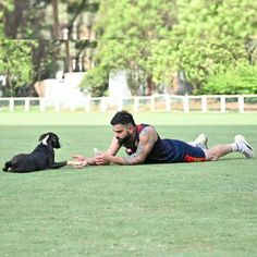 a man laying on the ground next to a dog