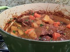 a pot filled with stew sitting on top of a stove