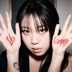 a woman with two hands painted red and no entry written on their palms, holding her hand up in front of her face