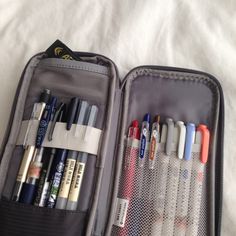 an open suitcase with pens and pencils in it that says what's in my pencil case