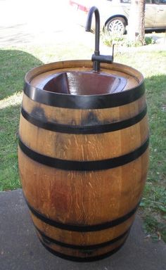 a wooden barrel sitting on top of a sidewalk